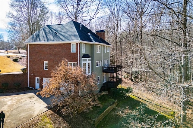 view of property exterior featuring brick siding and a chimney