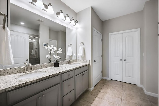 bathroom featuring a shower with door, tile patterned floors, and vanity