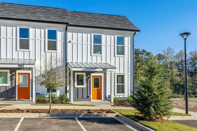 697 Fayetteville Rd # 303, Atlanta, GA 30316 - view of property featuring uncovered parking, a shingled roof, board and batten siding, a standing seam roof, and metal roof