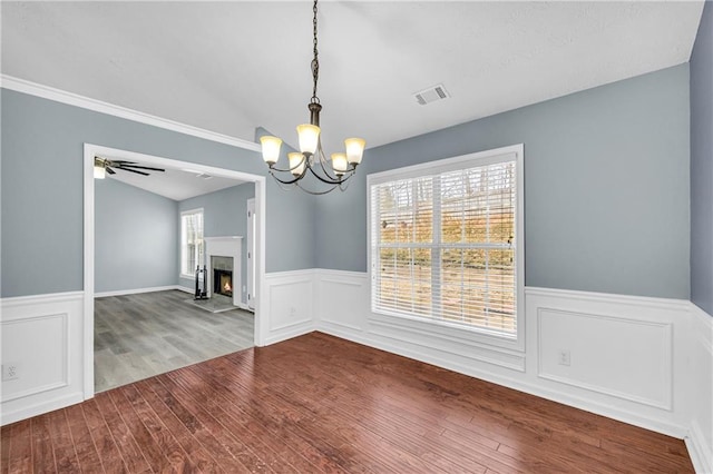 unfurnished dining area featuring lofted ceiling, hardwood / wood-style flooring, and ceiling fan with notable chandelier