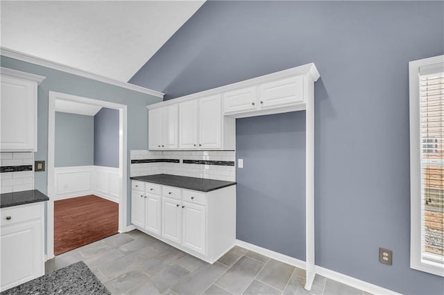 kitchen with white cabinets, lofted ceiling, and backsplash