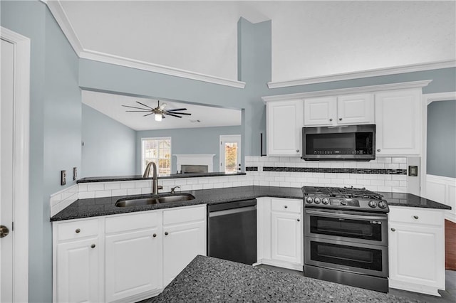 kitchen featuring stainless steel appliances, white cabinetry, sink, and dark stone counters