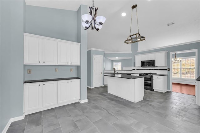 kitchen featuring white cabinets, a chandelier, hanging light fixtures, double oven range, and a high ceiling