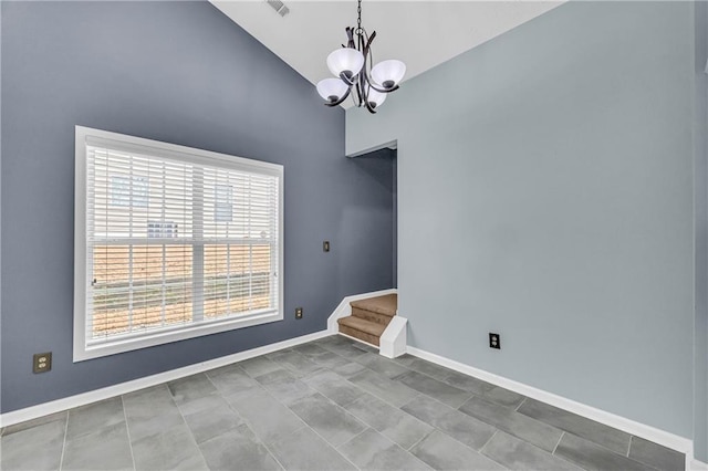 empty room featuring lofted ceiling and an inviting chandelier