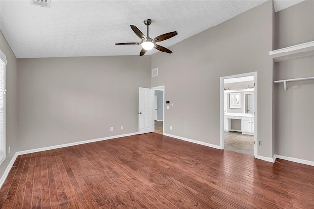 unfurnished bedroom with ensuite bathroom, hardwood / wood-style floors, ceiling fan, a textured ceiling, and a closet