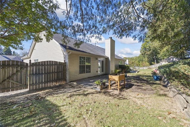 rear view of property featuring a lawn and a patio