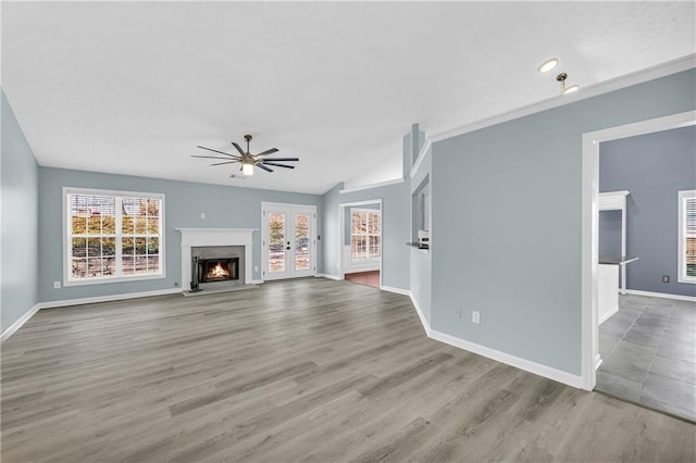 unfurnished living room with vaulted ceiling, light hardwood / wood-style floors, french doors, and ceiling fan