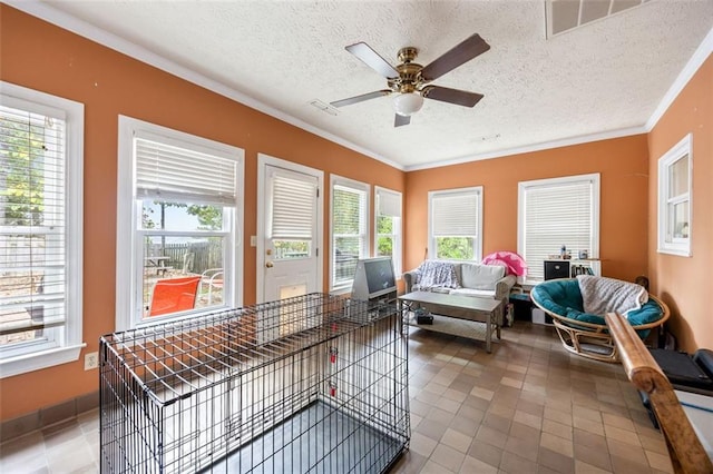 sunroom featuring ceiling fan and plenty of natural light