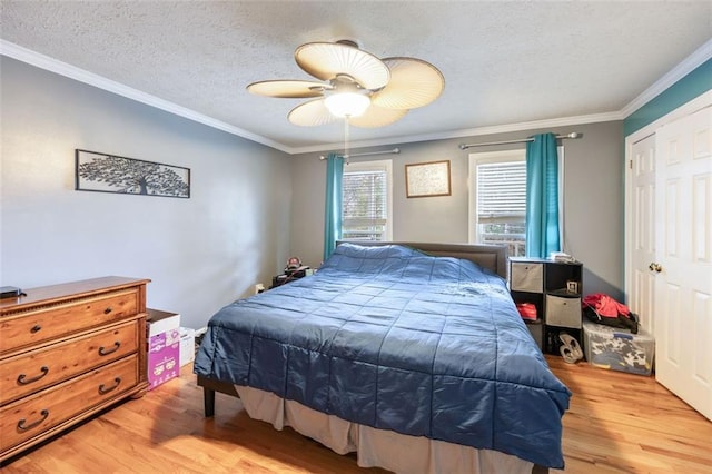 bedroom featuring light hardwood / wood-style floors, ornamental molding, a textured ceiling, and ceiling fan