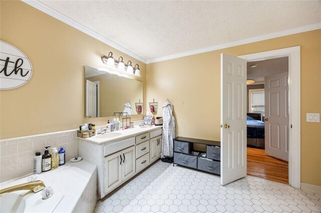 bathroom featuring vanity, a textured ceiling, wood-type flooring, and ornamental molding