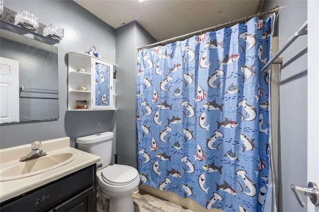 bathroom featuring vanity, a textured ceiling, and toilet