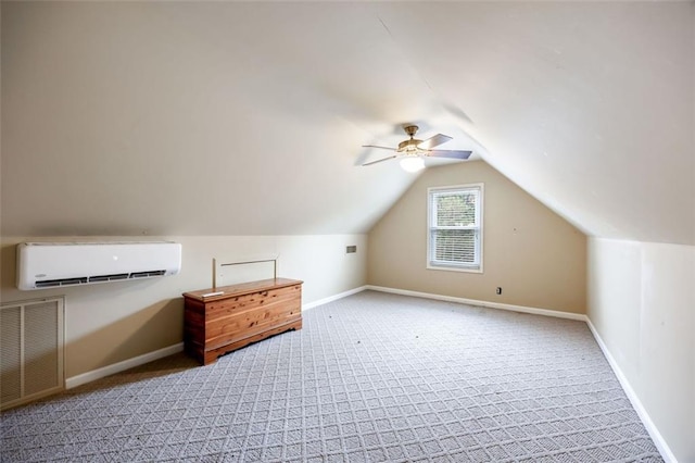 additional living space with a wall mounted air conditioner, lofted ceiling, light colored carpet, and ceiling fan