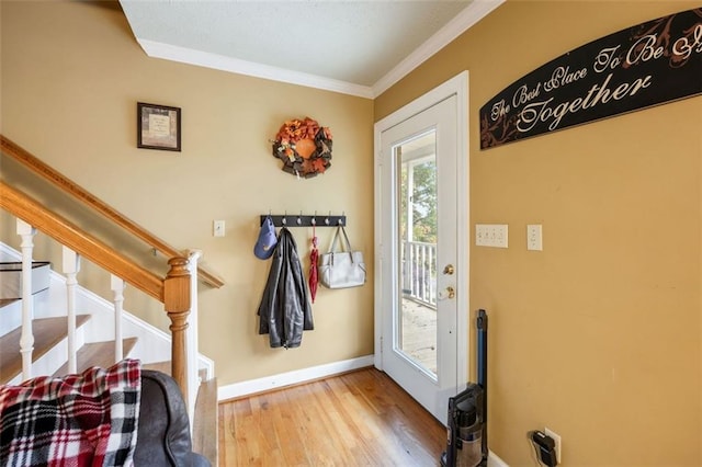 entryway with wood-type flooring and ornamental molding