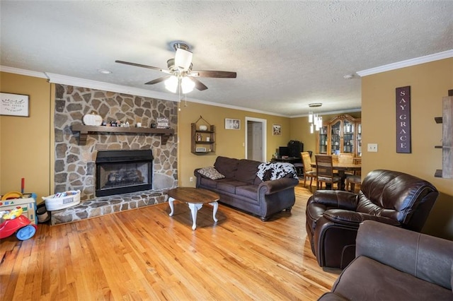 living room with crown molding, hardwood / wood-style flooring, a fireplace, and ceiling fan