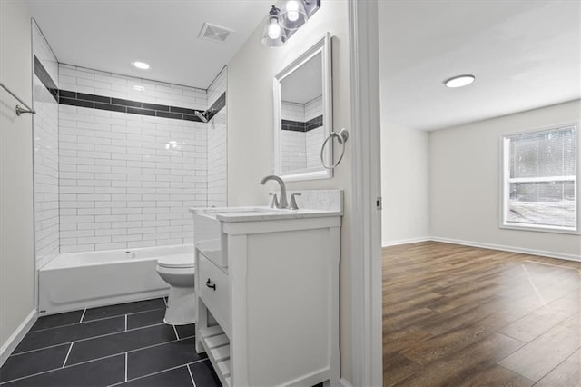 full bathroom with vanity, toilet, tiled shower / bath combo, and wood-type flooring