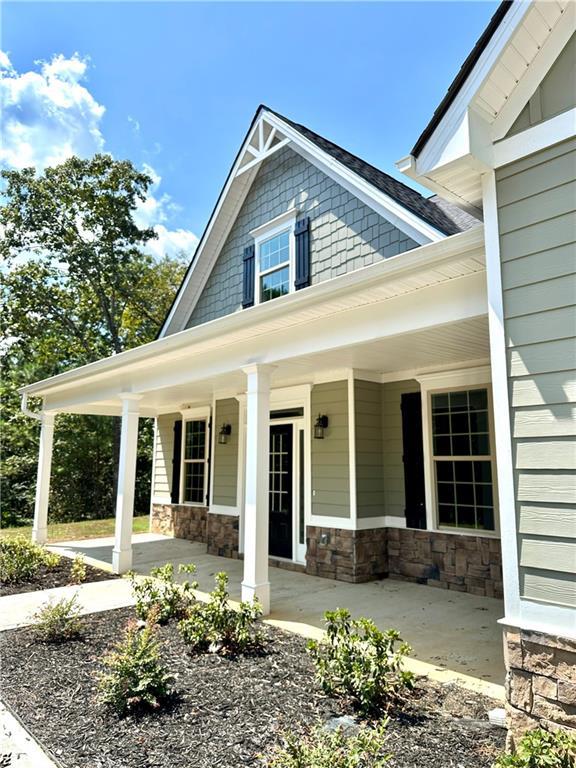 exterior space featuring a porch and stone siding