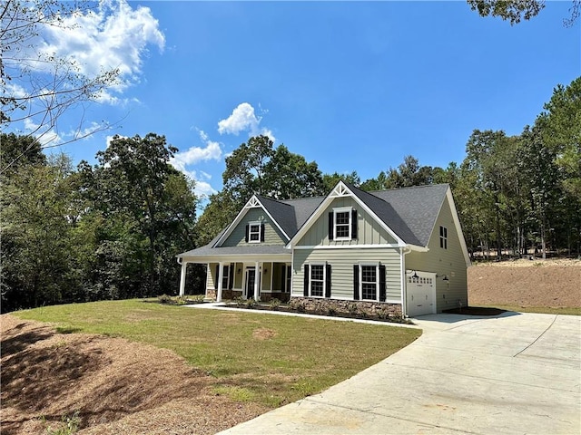 craftsman house featuring board and batten siding, a garage, stone siding, driveway, and a front lawn