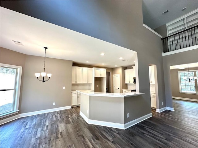 kitchen featuring light countertops, white cabinetry, baseboards, and an inviting chandelier