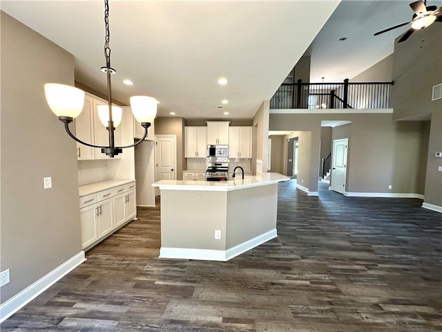 kitchen with light countertops, hanging light fixtures, white cabinets, and stainless steel appliances