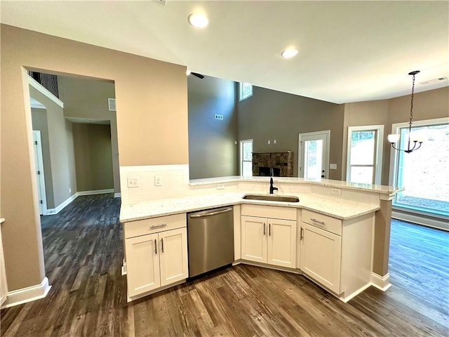 kitchen with a sink, light stone countertops, white cabinetry, and stainless steel dishwasher