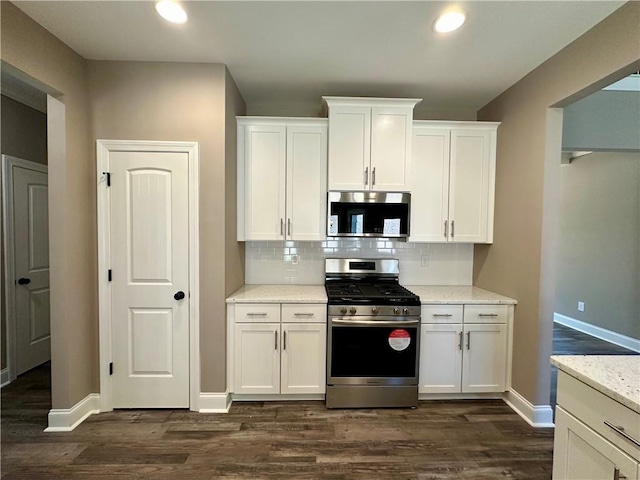 kitchen with appliances with stainless steel finishes, white cabinets, and light stone counters