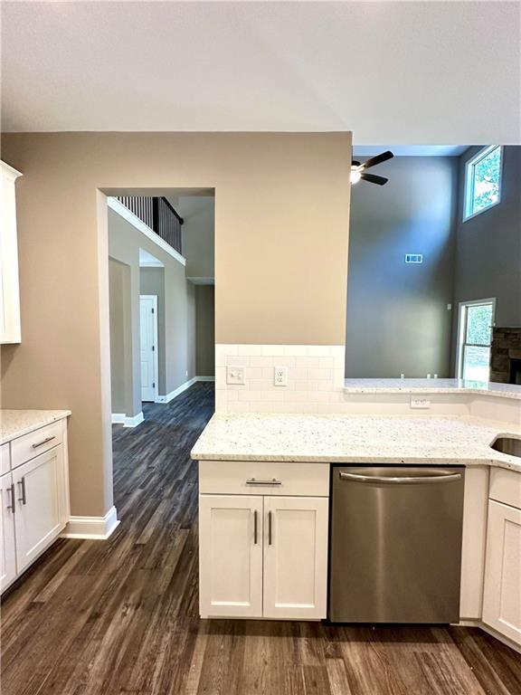 kitchen featuring white cabinetry, light stone counters, and dishwasher