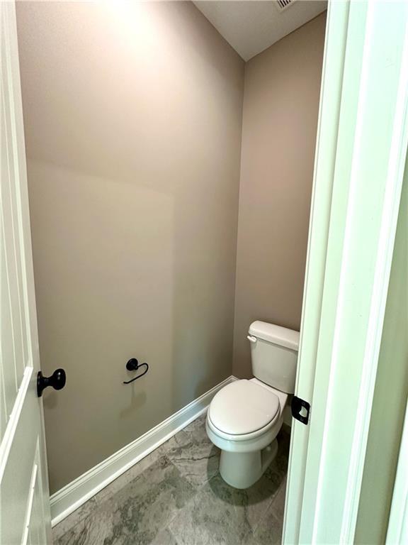 bathroom with toilet and baseboards