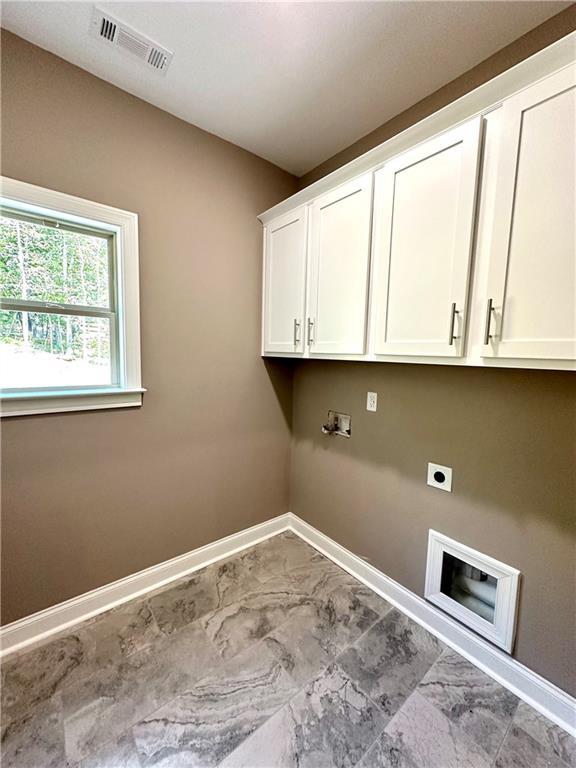 laundry area with visible vents, baseboards, marble finish floor, cabinet space, and electric dryer hookup