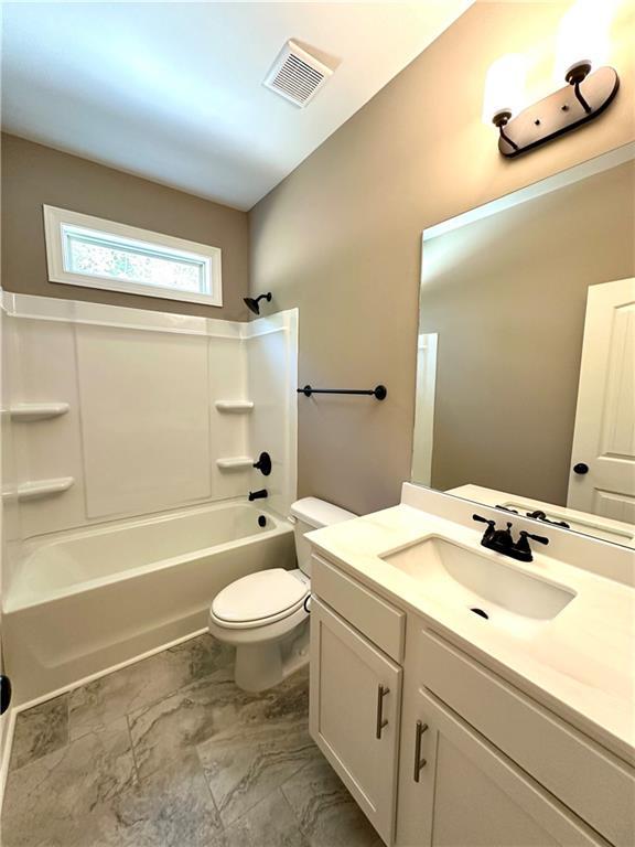 bathroom featuring visible vents, vanity, toilet, and shower / bathtub combination