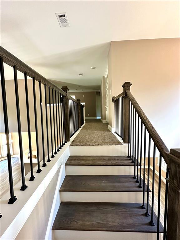 stairway featuring baseboards and visible vents