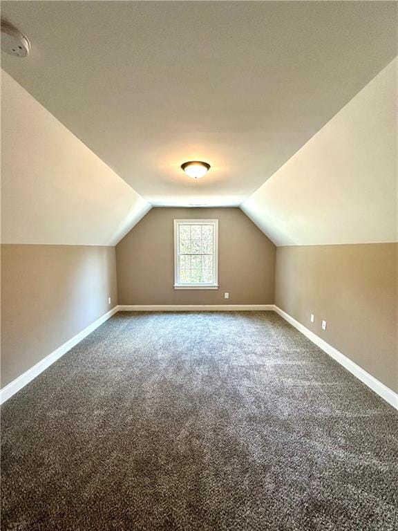 bonus room featuring lofted ceiling, carpet floors, and baseboards