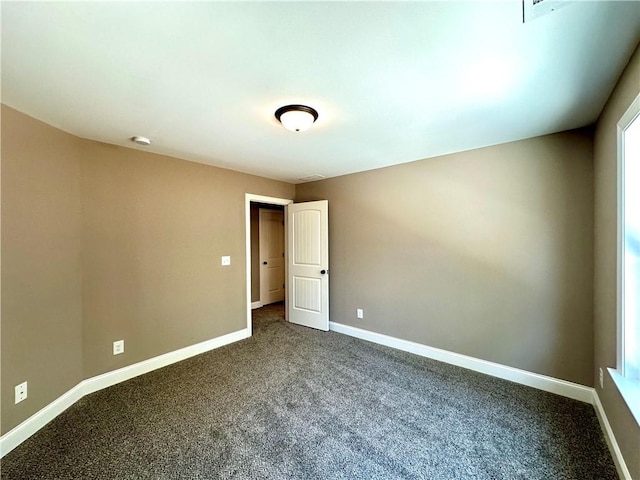 spare room featuring carpet and baseboards