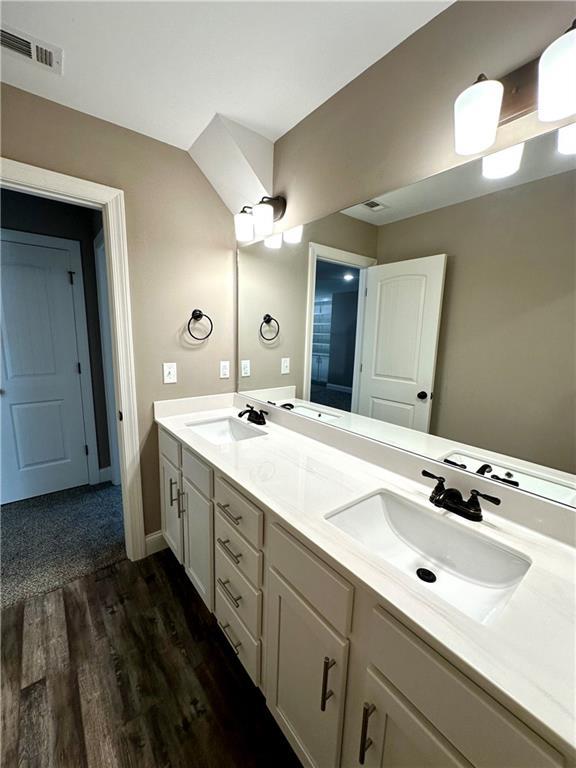 full bathroom featuring visible vents, a sink, and double vanity