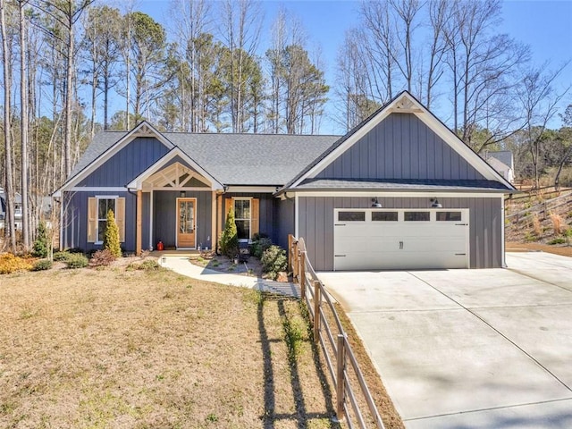 view of front facade featuring driveway, an attached garage, a shingled roof, and board and batten siding