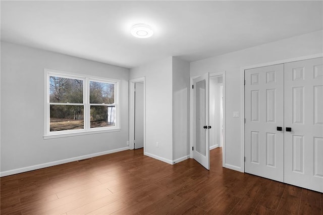 unfurnished bedroom featuring dark hardwood / wood-style floors and a closet