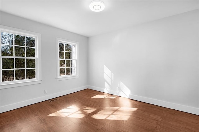 unfurnished room with hardwood / wood-style flooring