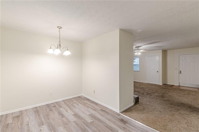 unfurnished dining area with light wood-type flooring and an inviting chandelier