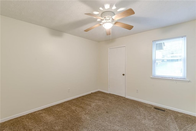 carpeted spare room featuring ceiling fan