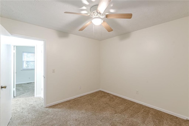 carpeted empty room featuring ceiling fan and a textured ceiling