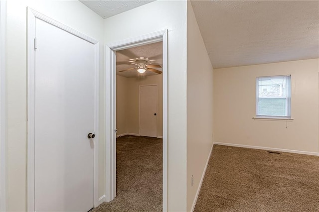 unfurnished room with a textured ceiling, light colored carpet, and ceiling fan