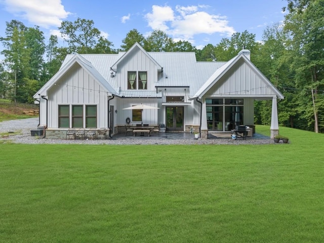 rear view of house with cooling unit, a lawn, and a patio area