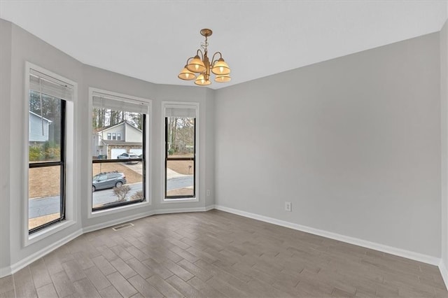 unfurnished room featuring wood-type flooring and a chandelier