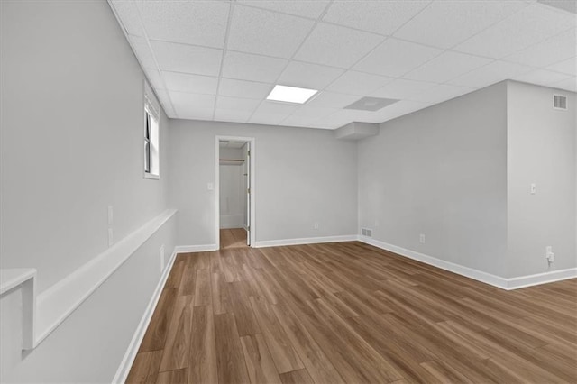 unfurnished room with wood-type flooring and a paneled ceiling