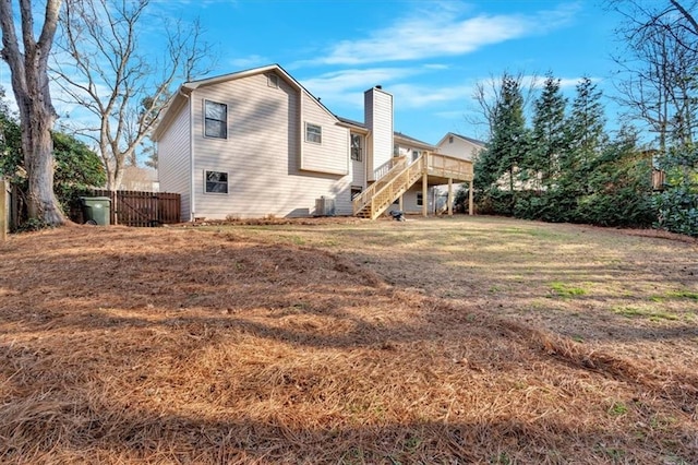 rear view of property featuring a yard and a deck