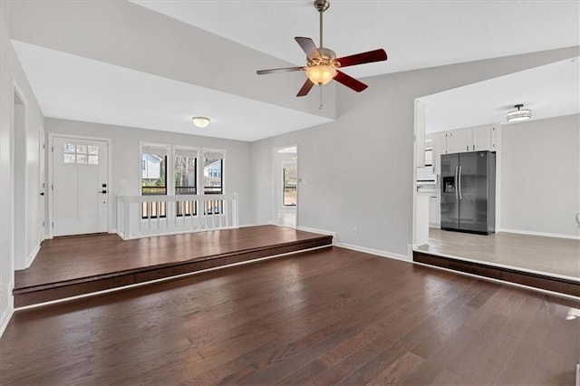 unfurnished living room with dark hardwood / wood-style floors and ceiling fan