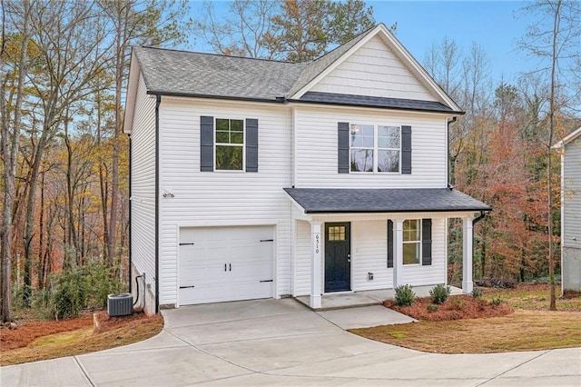 view of front of property featuring a porch, cooling unit, and a garage