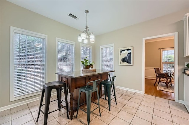 dining room featuring light tile patterned floors and a chandelier