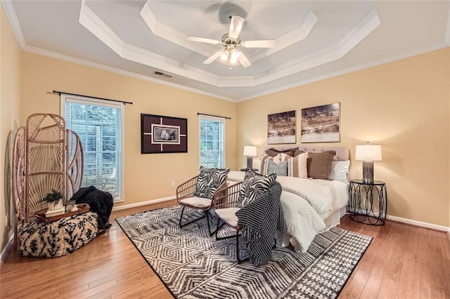 bedroom with multiple windows, ceiling fan, and wood-type flooring