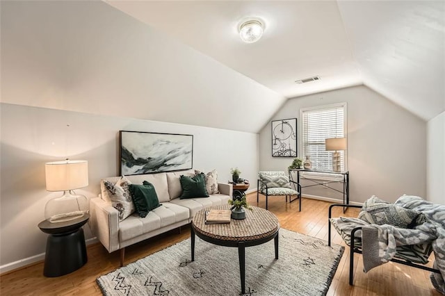 living room with hardwood / wood-style floors and lofted ceiling