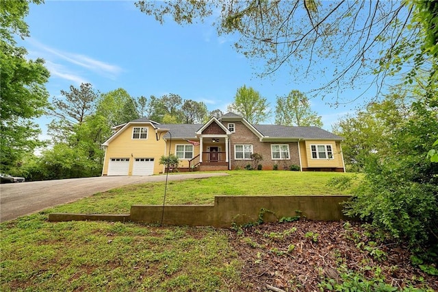 view of front of property featuring a garage, driveway, and a front lawn